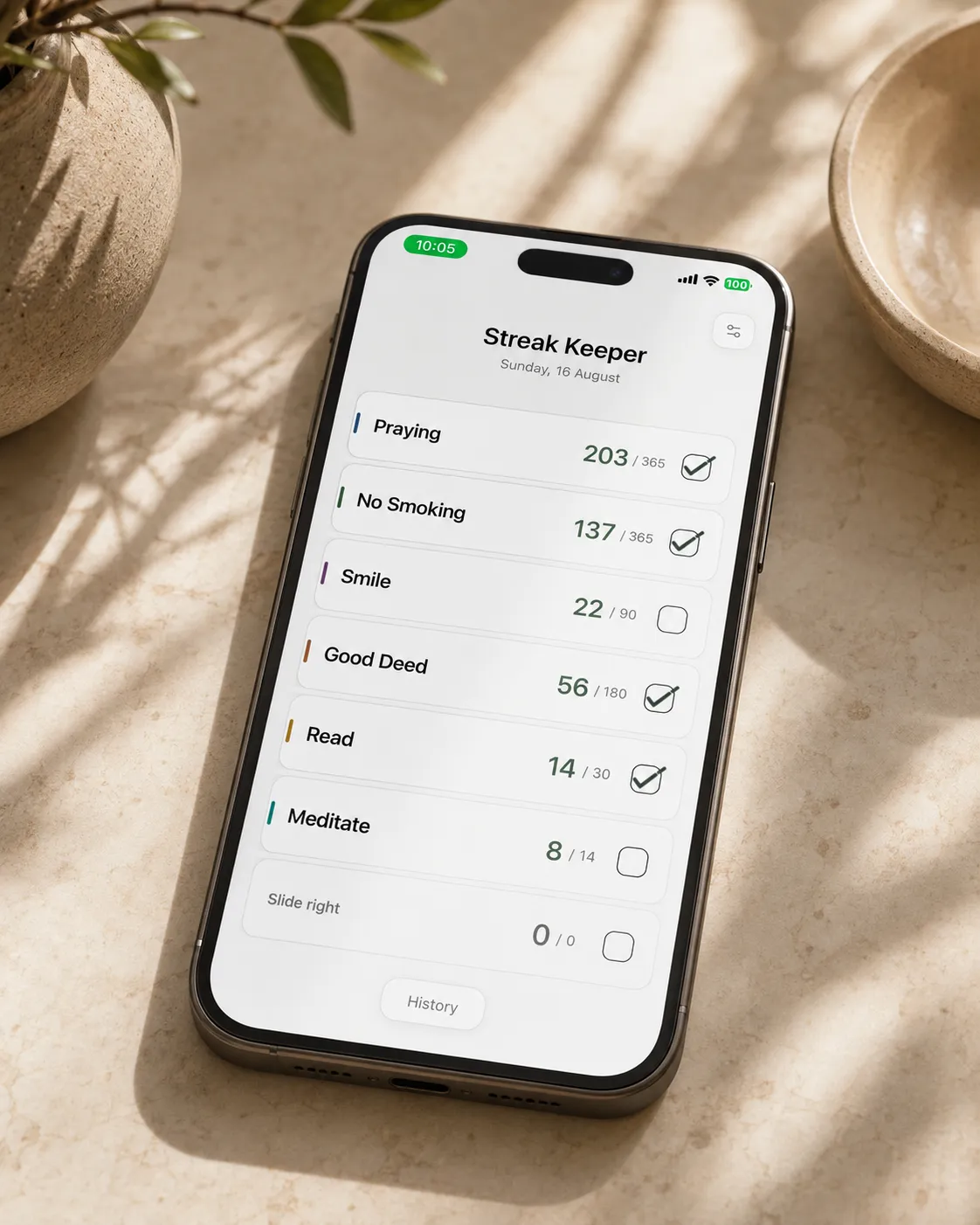 An iPhone on a wooden tabletop showing the Streak Keeper home screen with a mix of checked and unchecked streaks for the day.